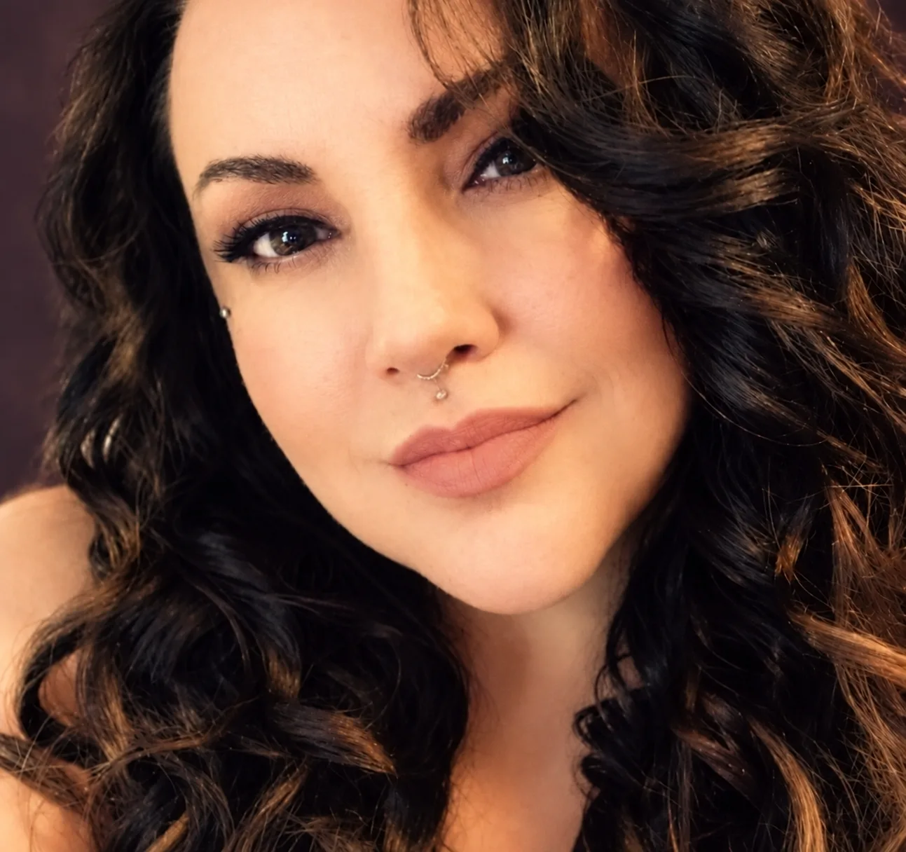 Portrait of Martha “Mizzy” Rivera, with long dark curls, looking toward the camera with a soft smile.